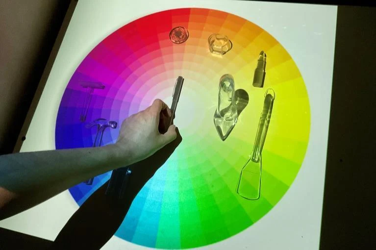 A visitor placing a transparent object on the color spectrum