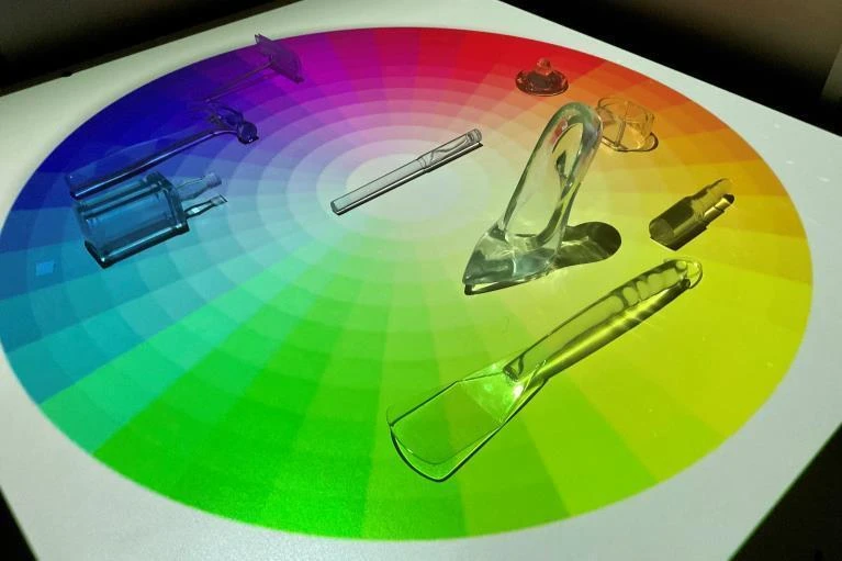 Transparent everyday objects arranged on a circular color spectrum