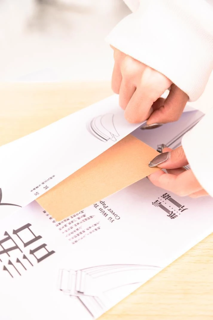 Folding the printed cover around a textbook.